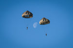 Parachutistes face à la lune